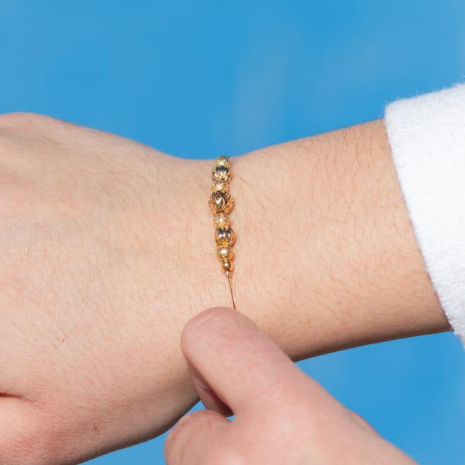 Bracelet Leslie doré au poignet, finesse éclatante et maillons délicats, éclat solaire.