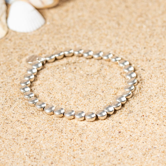 Bracelet Nasa en métal argenté, perles texturées sur fil souple, élégance minimaliste.