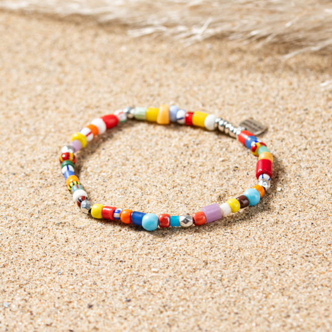 Mise en scène sur sable doré du bracelet Wonka, idéal pour accessoiriser l’été.