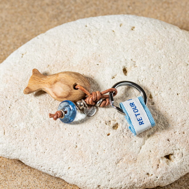 Porte-clefs If : composé d'un poisson en bois, d'un cordon en cuir marron, d'une perle en verre recyclé bleu plate et d'une perle argentée ronde.