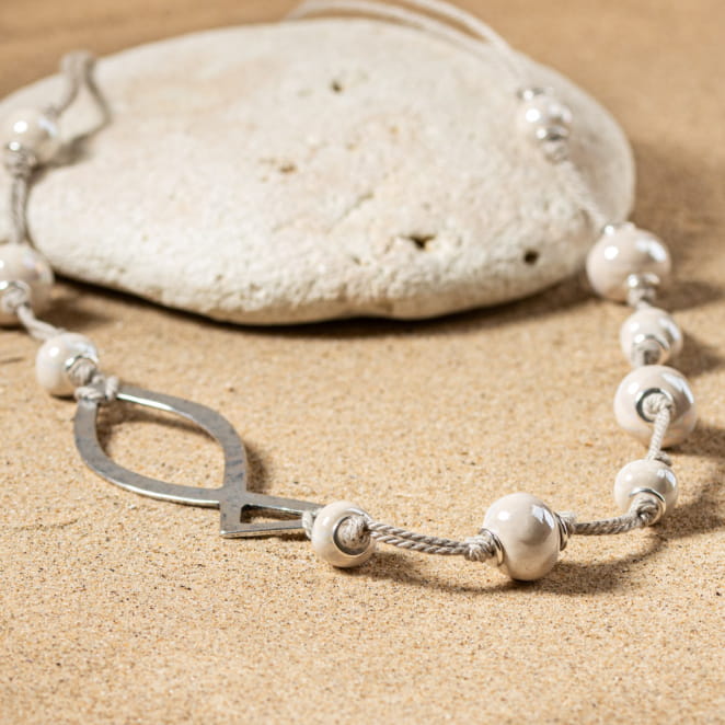 sautoir Ottel en métal argenté, perle blanche nacrée sur fond sable