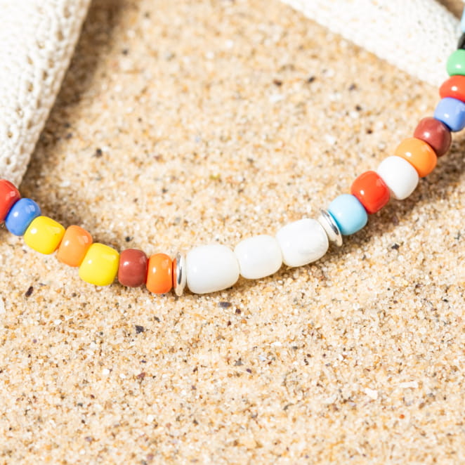 Gros plan sur le bracelet Dragan, couleurs vives et liens tressés, une touche estivale et artisanale.