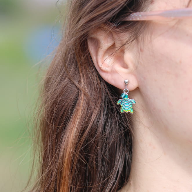 Bijou artisanal : boucles d’oreilles argentées avec perles vertes éclatantes.