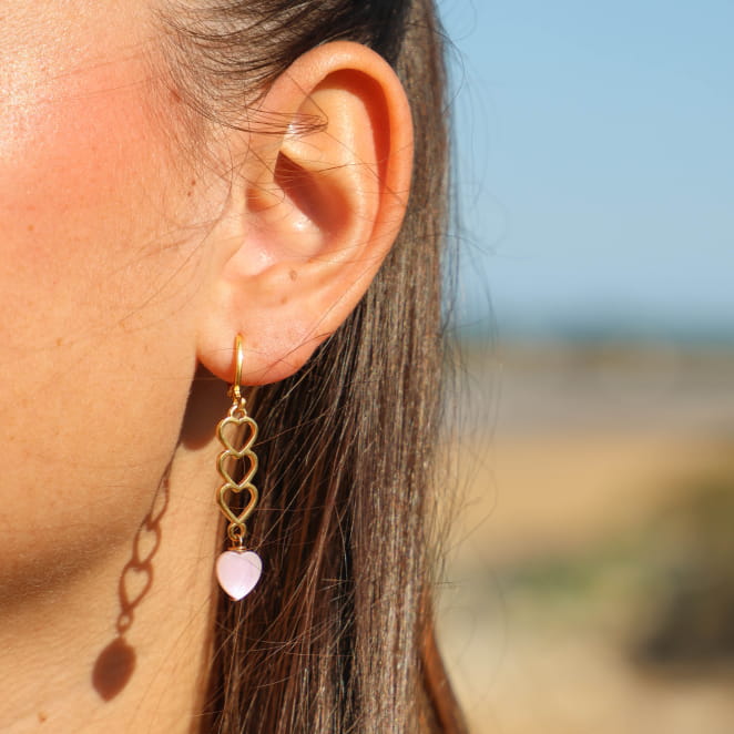 Boucles d'oreilles Aina Retour de Plage en métal doré 24 carats, trois cœurs dorés enchaînés, perle en nacre rose en forme de cœur, monture en dormeuse dorée – bijou artisanal fabriqué en France