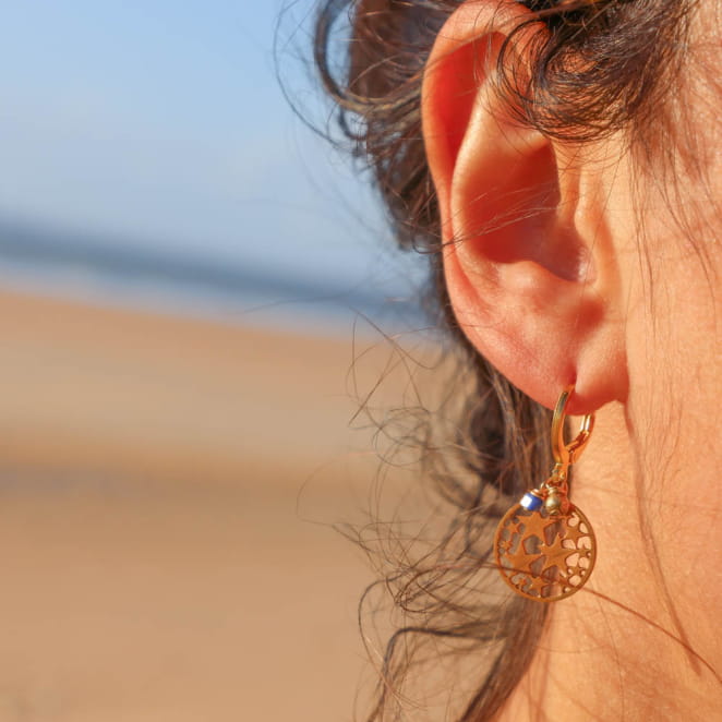 Boucles Phoebe dorées, perles bleu profond, portées en gros plan – création artisanale Retour de Plage