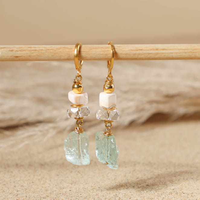 boucles d’oreilles Rocher doré avec perles vert d’eau posées sur fond sable