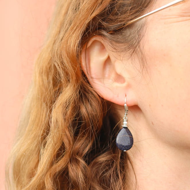 Boucles en métal argenté texturé, pendantes, avec perles bleu marine scintillantes.