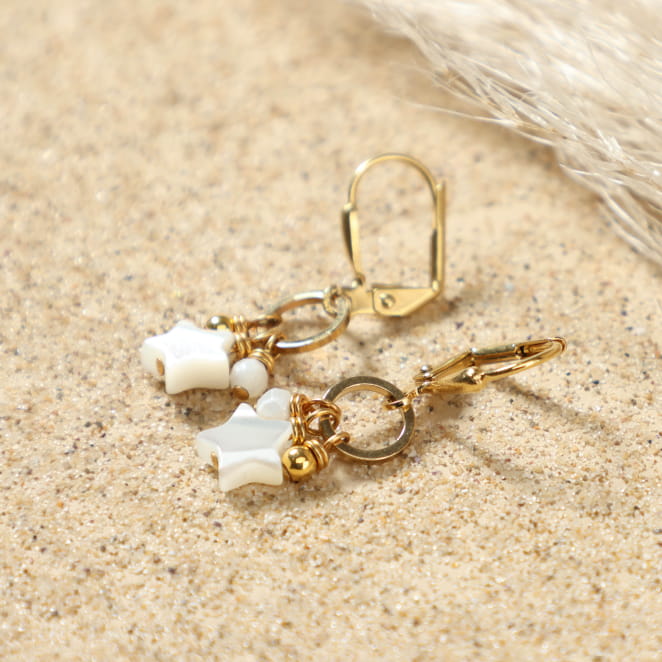 Détail des boucles d'oreilles Vega avec pendentifs en étoile et perles en nacre blanche, fermoir dormeuse doré – création artisanale française