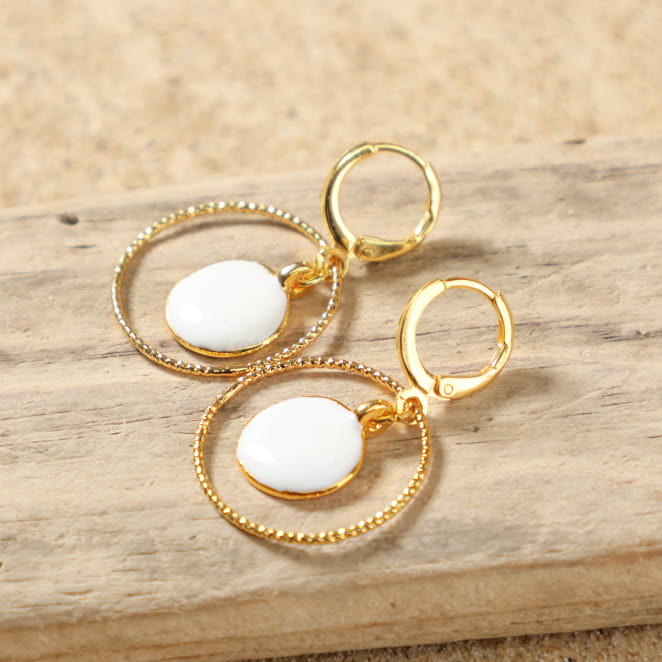 Détail des boucles d'oreilles Zagora avec pendentif rond en émail blanc et monture dorée – création artisanale française élégante