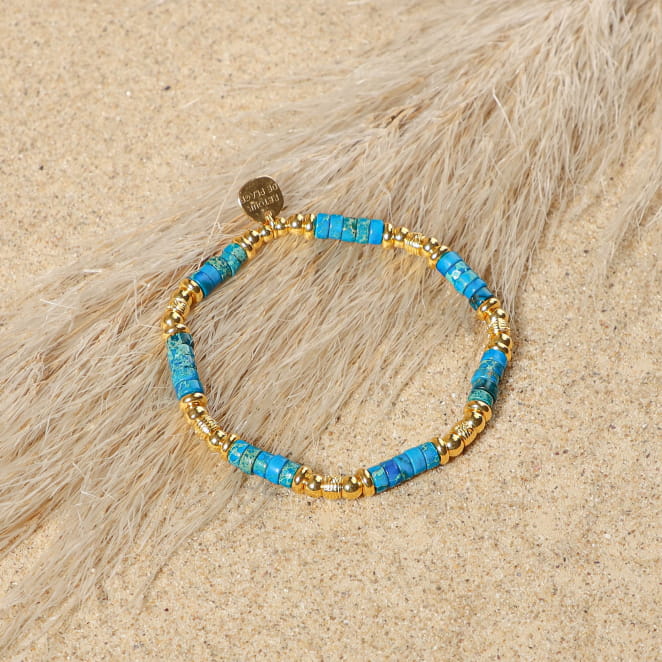 bracelet Carolina doré avec perles bleues sur sable clair