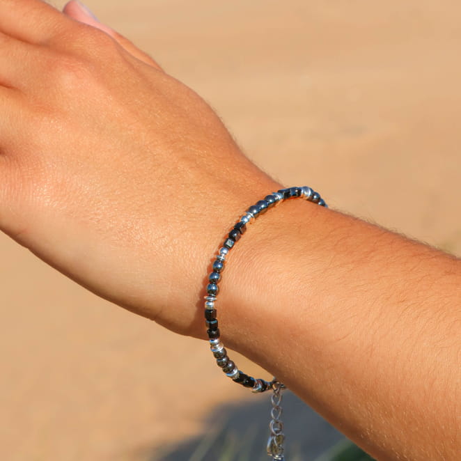 Bracelet Cité Retour de Plage en perles d’hématite noires brillantes, perles de pierre noire et perles en métal plaqué argent 999, avec médaille Retour de Plage – bijou artisanal fabriqué en France