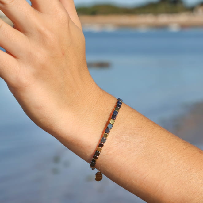 bracelet Coraline doré et noir porté au poignet, design fin et élégant