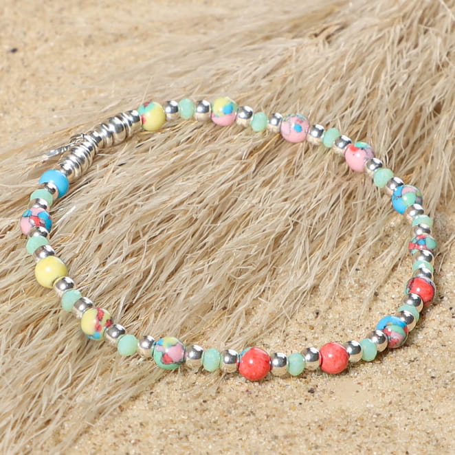 bracelet Doux argenté avec perles multicolores sur sable clair
