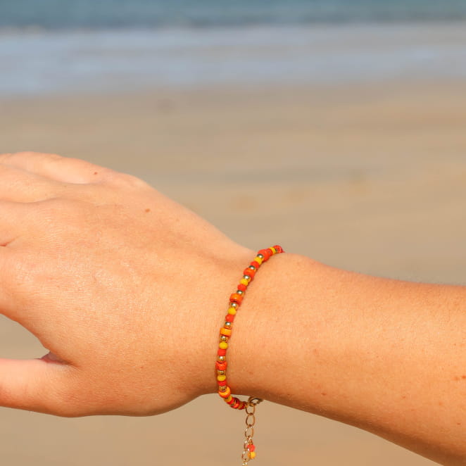 Bracelet artisanal Felicita doré, perles orange et multicolores, création française.