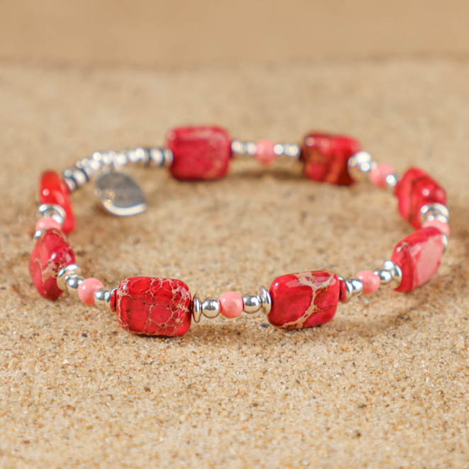 Bracelet Flora argenté avec perles fuchsia, posé sur fond sableux – bijou fait main en France