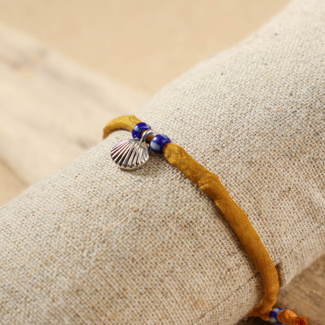 bracelet Friendly argenté avec cordon moutarde sur support sable clair