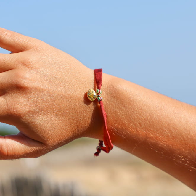 bracelet Friendly doré avec cordon rouge porté au poignet