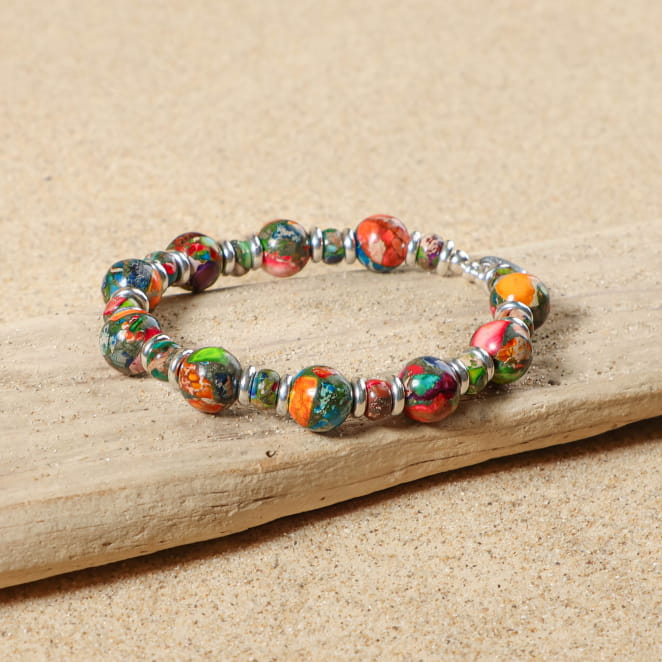 bracelet Jungle argenté avec perles multicolores sur sable clair