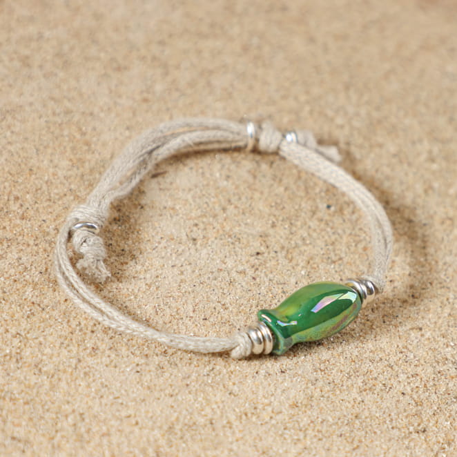 Détail du bracelet Killa avec cordon en lin, pendentif poisson en céramique verte et perles argentées, ajustable grâce à ses nœuds coulissants – création artisanale française élégante
