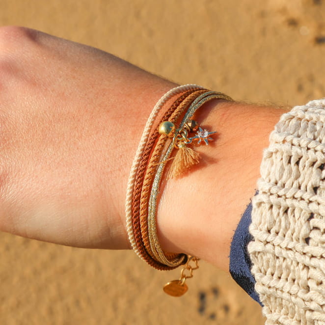 Bracelet Lison doré aux perles marron et multicolores, porté en superposition – bijou artisanal