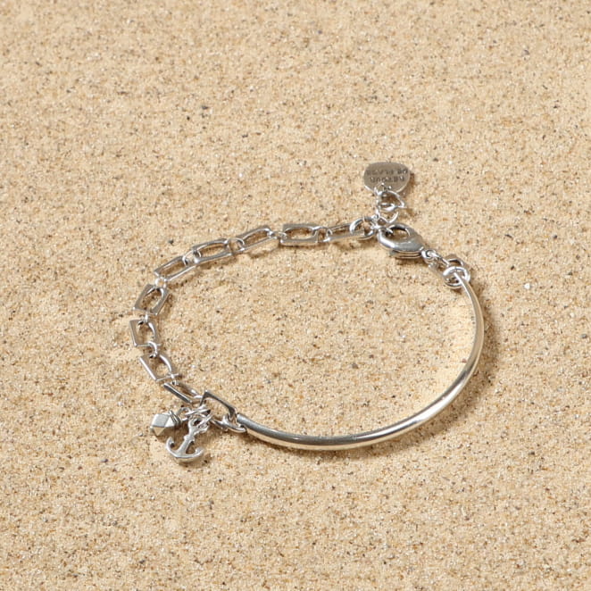 bracelet Port argenté avec maillons fins posé sur tissu clair