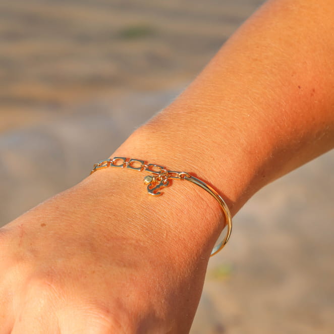 bracelet Port argenté et doré porté au poignet, finition délicate et ajustable