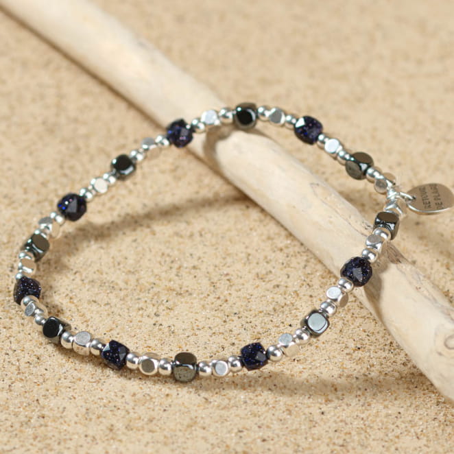 Bracelet Radeau argenté, perles bleues marine profond, posé sur sable – bijou fait main en France
