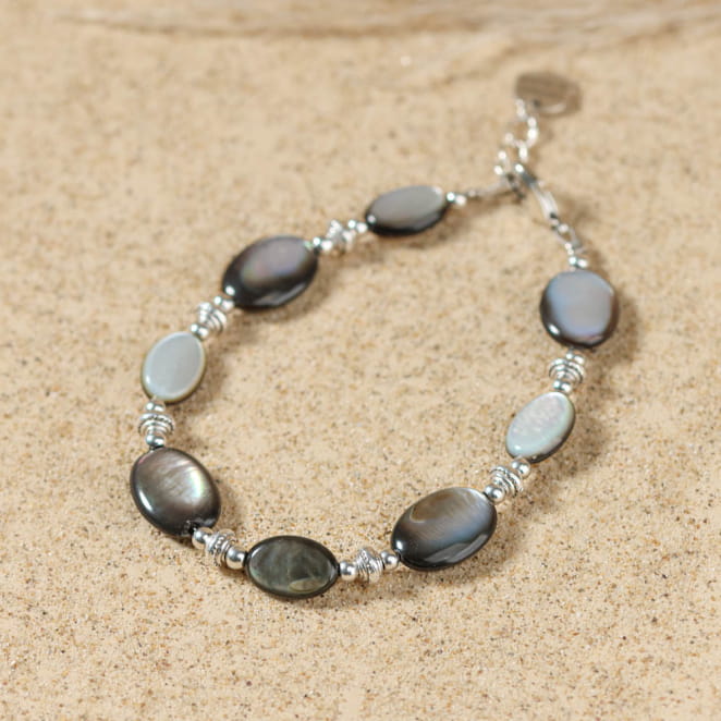 Bracelet gris anthracite et argenté, posé sur le sable – fabrication française artisanale