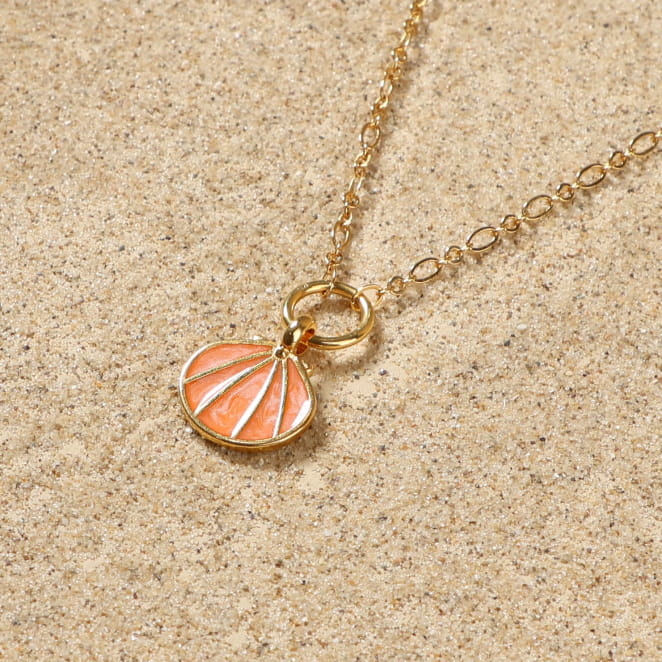 collier Caliope doré avec pendentif rond à motif corail sur sable clair