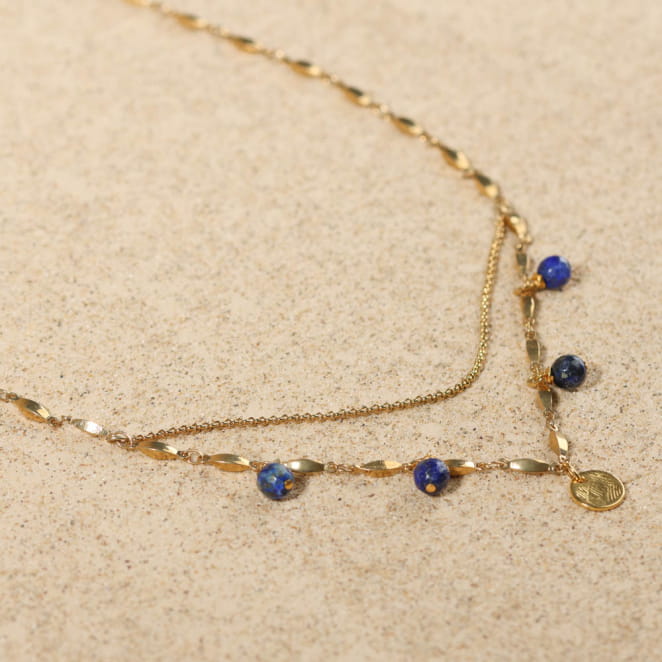 Détail du collier Casta, mélange de mailles argentées et perles bleu profond, esprit bord de mer.