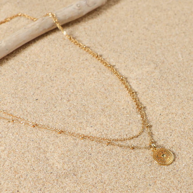 Collier doré minimaliste sur fond sable, création faite main en France