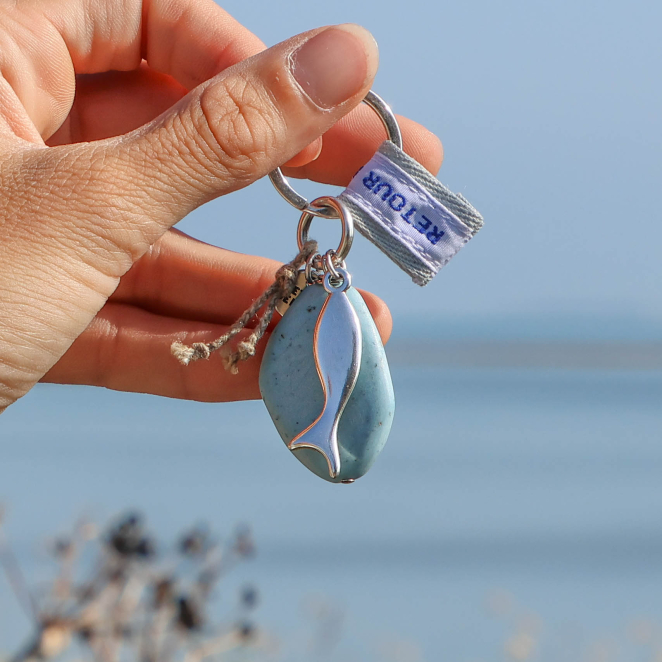 porte-clés Maumusson argenté et bleu tenu en main